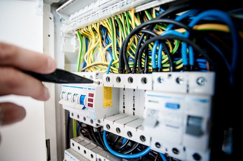 Autoriseret elektriker i Aalborg arbejder på sikringstavle med professionelt værktøj